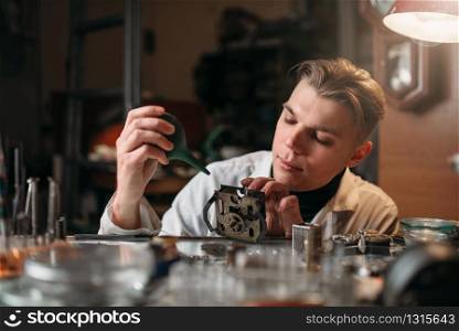 Watchmaker cleans the mechanism of old watches. Clock maker at work. Watchmaker cleans the mechanism of old watches