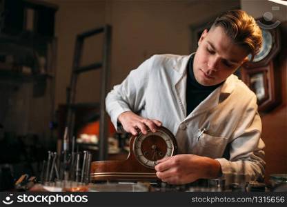 Watchmaker restore old wooden table clock. Clock maker at work. Watchmaker restore old wooden table clock