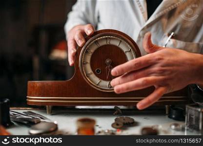 Watchmaker restore old wooden table clock. Clock maker at work