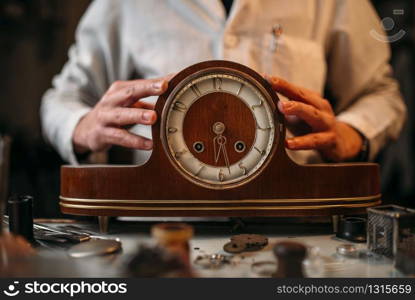 Watchmaker restore old wooden table clock. Clock maker at work. Watchmaker restore old wooden table clock