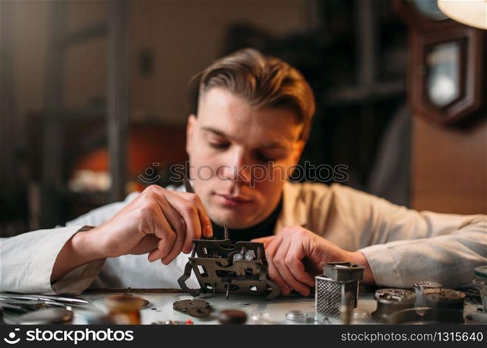 Watchmaker with loupe repair clockwork mechanism. Clock maker at work. Watchmaker with loupe repair clockwork mechanism