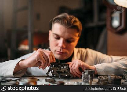 Watchmaker with loupe repair clockwork mechanism. Clock maker at work. Watchmaker with loupe repair clockwork mechanism