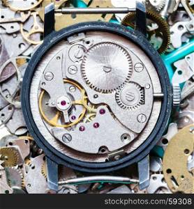 watchmaker workshop - mechanical clockwork on heap of clock spare parts