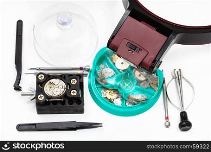 watchmaker workshop - set of tools with head-mounted magnifier and spare parts for repairing mechanical watch on white background