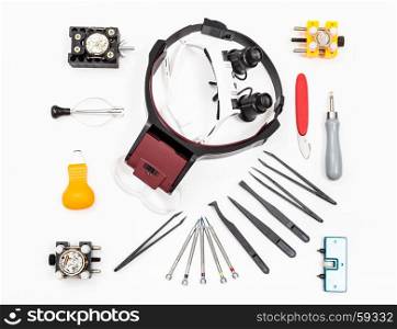 watchmaker workshop - top view of equipments for repairing watch on white background