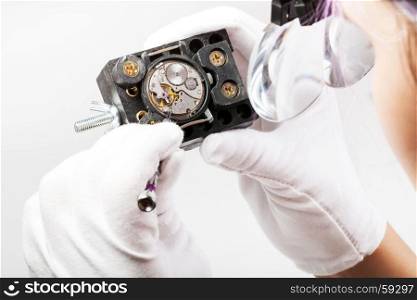 watchmaker workshop - watchmaker in head-mounted magnifying glasses repairs old mechanical wristwatch with screwdriver