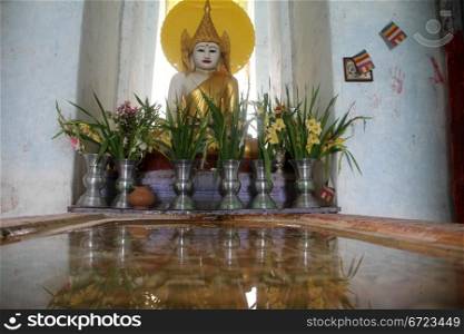 Water and Buddha inside white buddhist temple in Mingun, Myanmar