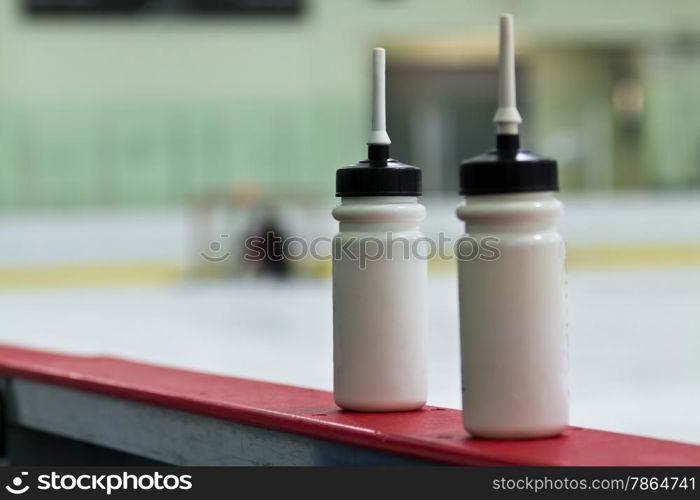 Water bottles on the boards in a hockey arena