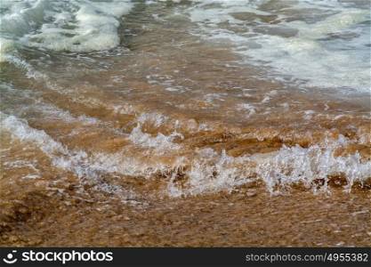 water breaking on sand background