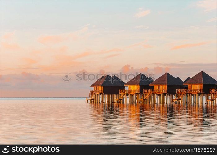 Water bungalows at sunset on Maldives. Water bungalows with turquiose water on Maldives
