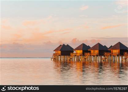 Water bungalows at sunset on Maldives. Water bungalows with turquiose water on Maldives