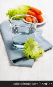 Water, carrot and lettuce - diet and healthy eating concept - over white