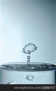 Water drop in rippled liquid closeup
