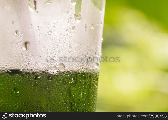 Water drop on plastic bottle of drink with green background background