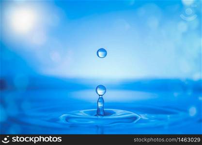 Water drop splash. Blue colored Background. Water drop splash on water surface.