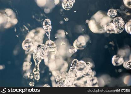Water drops levitation on blue background. Water splash freezed in air