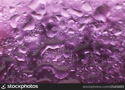 water drops on a purple background. Abstract purple background. Water drops on glass. Natural background toned in purple.. water drops on a purple background. Abstract purple background. Water drops on glass.