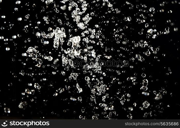 Water drops on black background flying in the air. Lewitation.