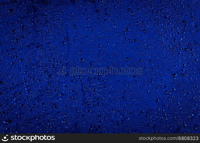 Water drops on dark blue stone surface texture background