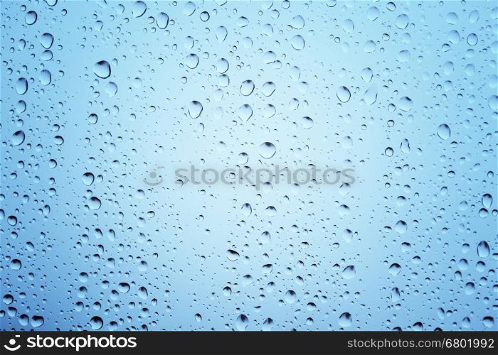 Water drops on glass blue toned background