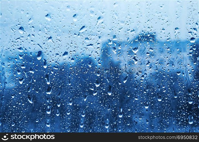 Water drops on glass, close-up naural bright blue texture