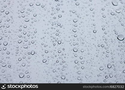 Water drops on glass white abstract background