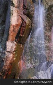 Water flowing down over big granite rock