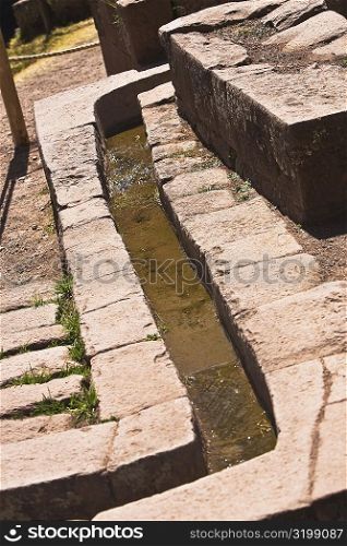 Water flowing through a stone&acute;s drain, Pisaq, Urubamba Valley, Peru