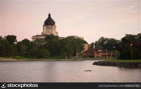 Water from the lake reflects the building in front of the capitol dome in Pierre, SD