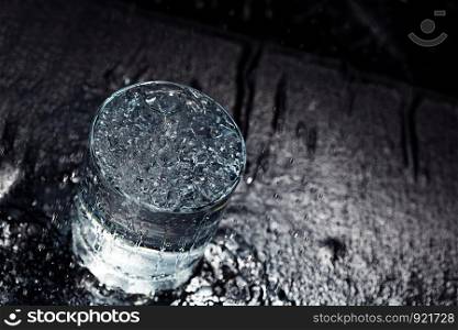 Water glass on a wet table. Close-up view