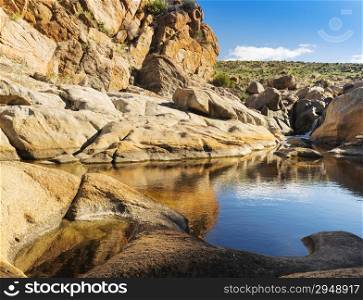 Water hole with tall cliffs in rural Australia&rsquo;s outback