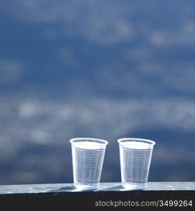 water in cup mountains on background