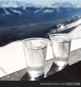 water in cup mountains on background