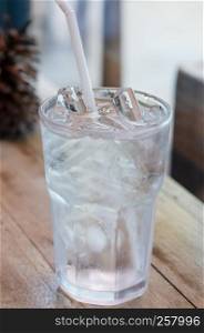 water in glass with ice and drinking straw on table. water in glass with ice on table