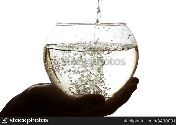 Water is poured into a large glass isolated on a white background