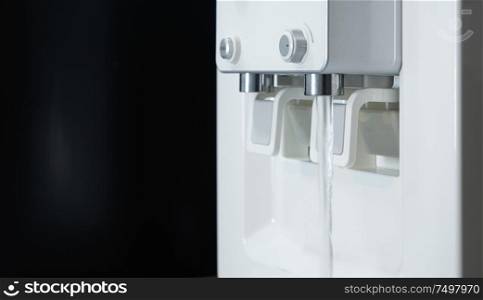 Water pouring from drinking fountain .