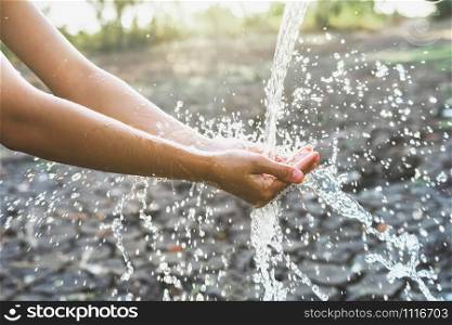 Water pouring in hand on nature background