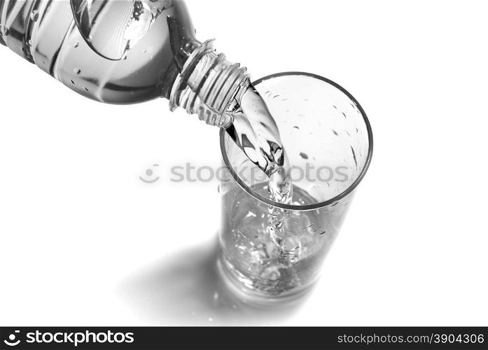water pouring into glass from bottle isolated on white