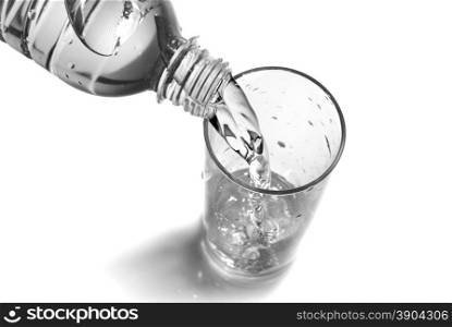 water pouring into glass from bottle isolated on white
