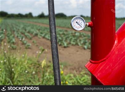 Water pump and pipes on farmland. Agriculture and watering concept.