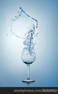 Water splashing out of a tall wine glass.