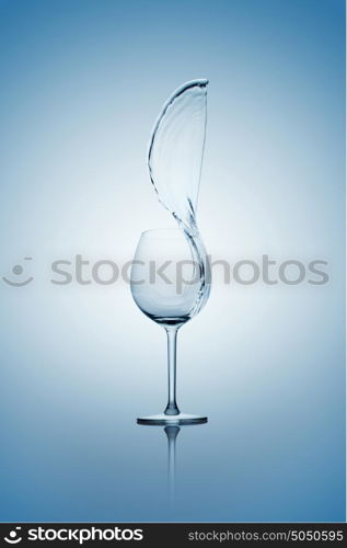 Water splashing out of a tall wine glass.