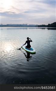 Water sports, surf lessons. Stand on a kayak on the water with the warm colors of a summer sunset. Water sports, surf lessons. Stand on a kayak on the water with the warm colors of a summer sunset.