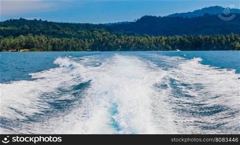 Water stream after speed boat. Trail on water surface behind of fast moving motor boat. Waves on blue sea