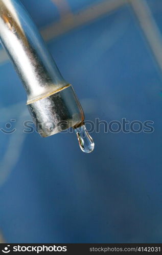 water tap closeup. Shallow depth of field, focus on the tap and the droplet