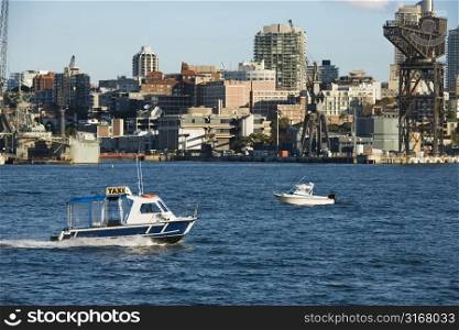 Water taxi boat in Sydney, Australia with city buildings.