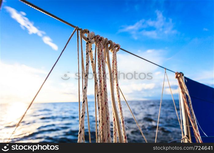 Water traveling, adventure concept. Sea view from yacht, rigging closeup, calm water, sunny weather, sky with many clouds.. Sea view from yacht, sunny weather