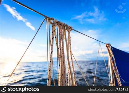 Water traveling, adventure concept. Sea view from yacht, rigging closeup, calm water, sunny weather, sky with many clouds.. Sea view from yacht, sunny weather