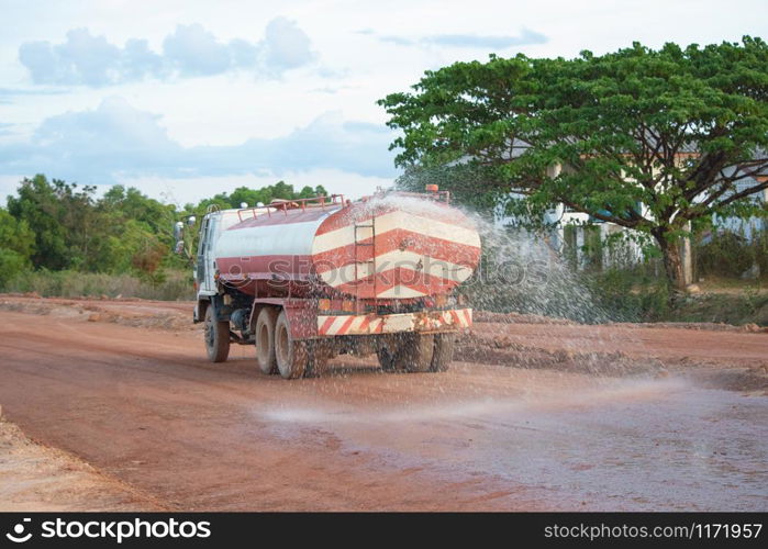 Water truck sprays water for a new road construction site.