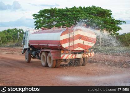 Water truck sprays water for a new road construction site.